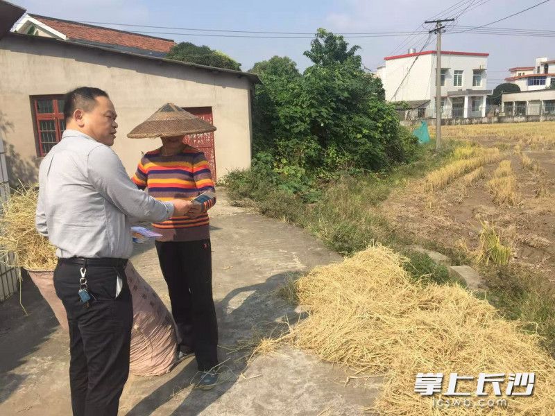 巡查人员与农民进行交流。罗忠亮 供图
