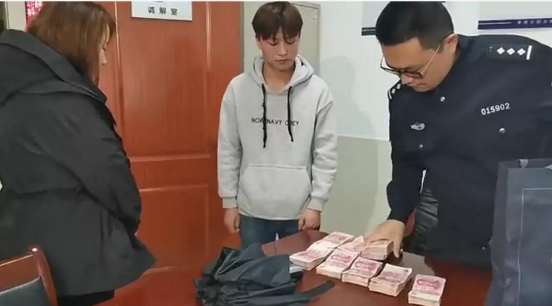 张永平在派出所将10万元现金还给失主。通讯员 供图