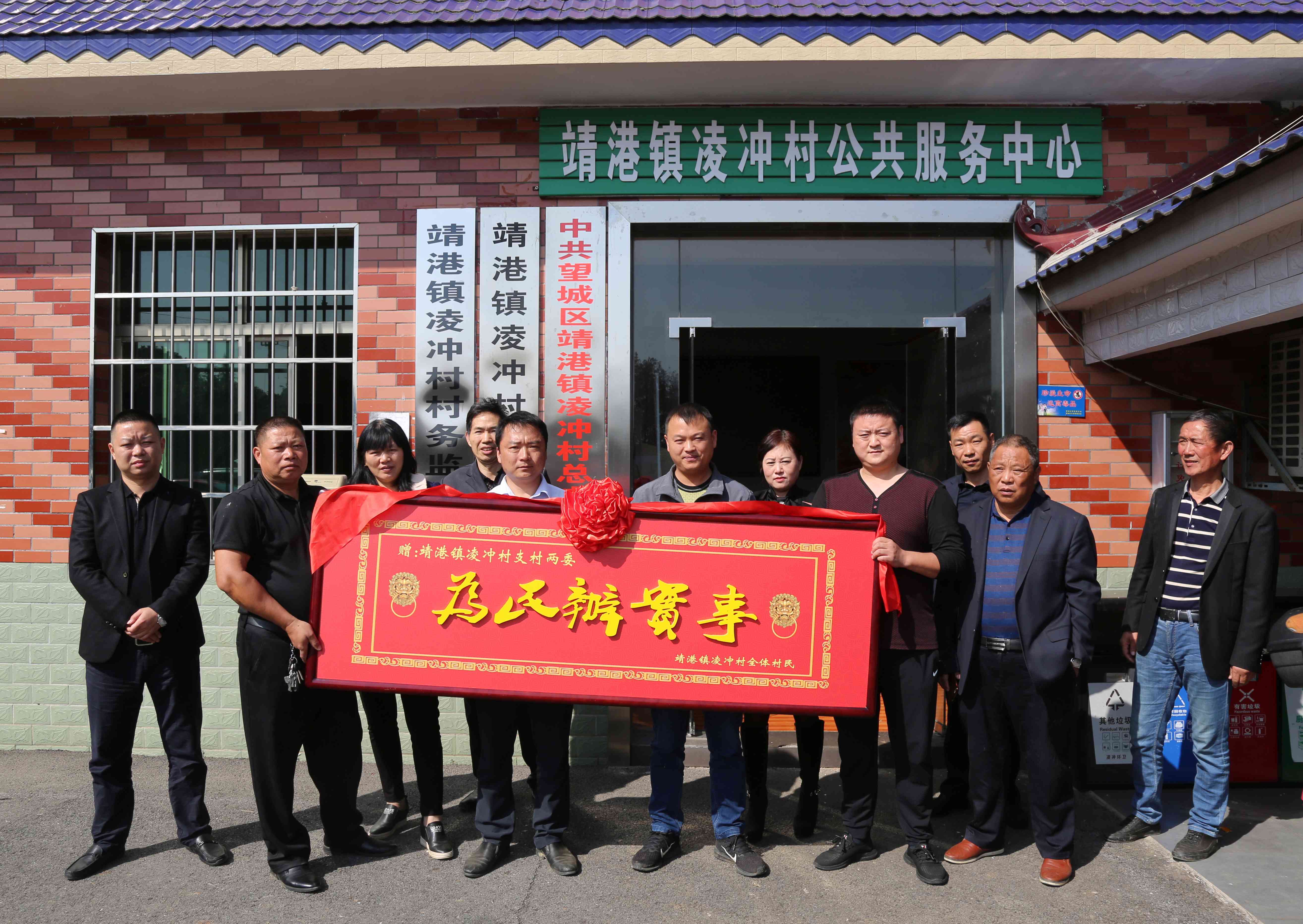 村民将一块写着"为民办实事"的大牌匾抬进村部，感谢村支两委为老百姓办好事。