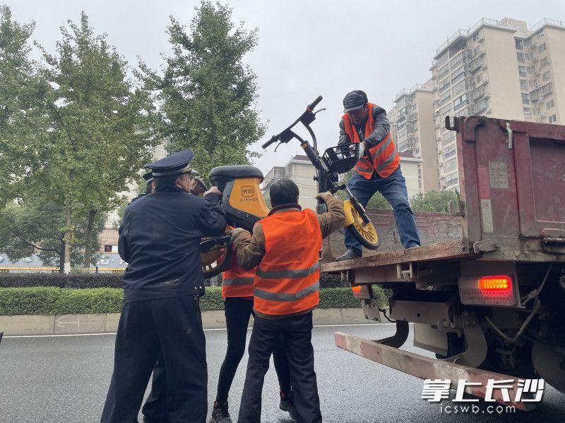 执法人员对违规共享电动车进行暂扣。 执法人员对违规共享电动车进行暂扣。
