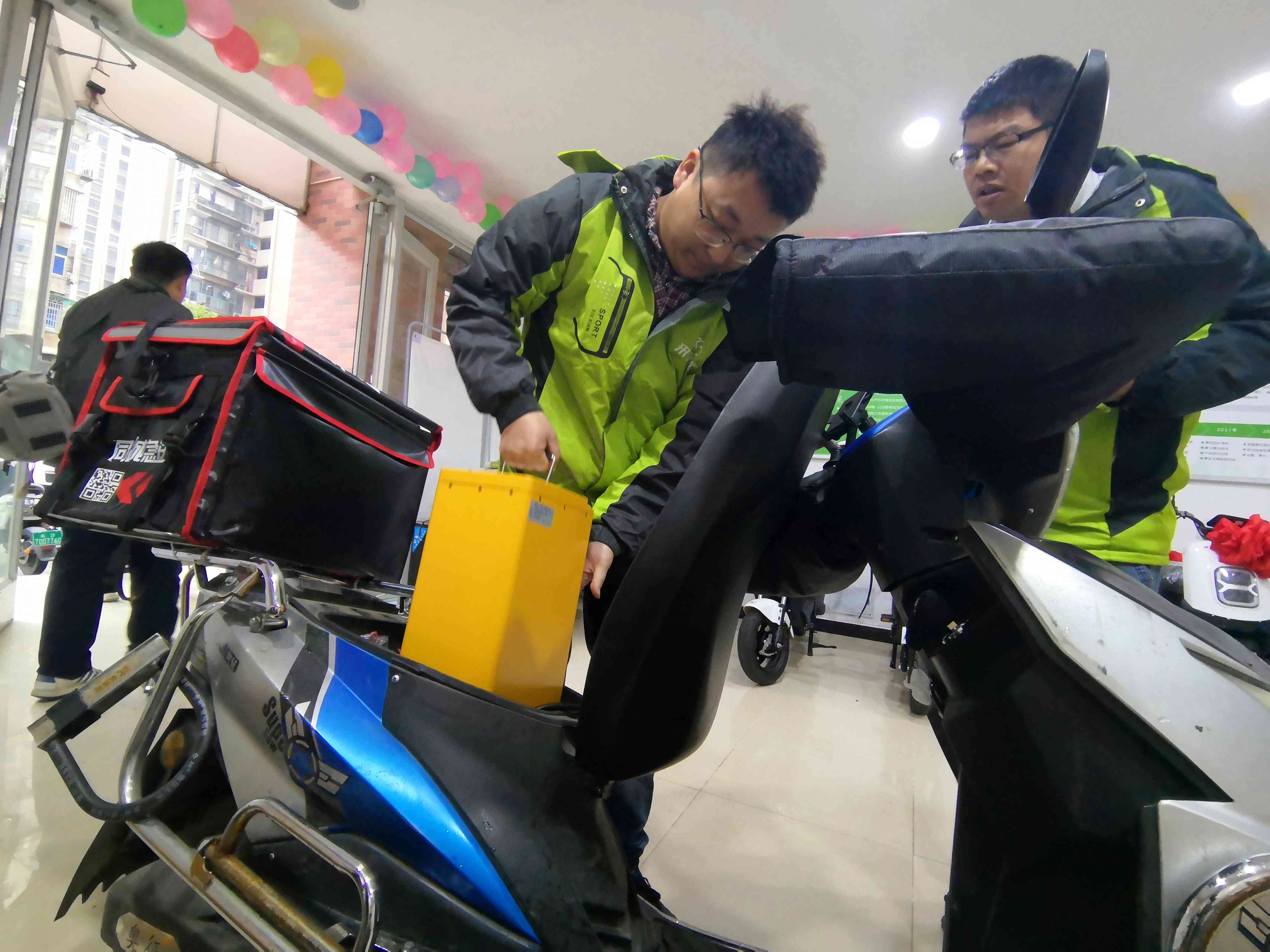 电动车5S站的工作人员正在为外卖骑手换电池。   均为长沙晚报全媒体记者贺文兵摄