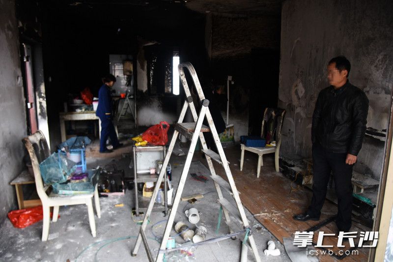 12月4日，杨先生在清理火场，现场当时被烧得一片狼藉。均为长沙晚报全媒体记者 刘琦 摄