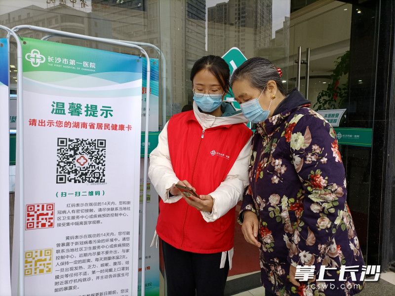 爱心志愿者在手把手教老年就医者使用智能手机。