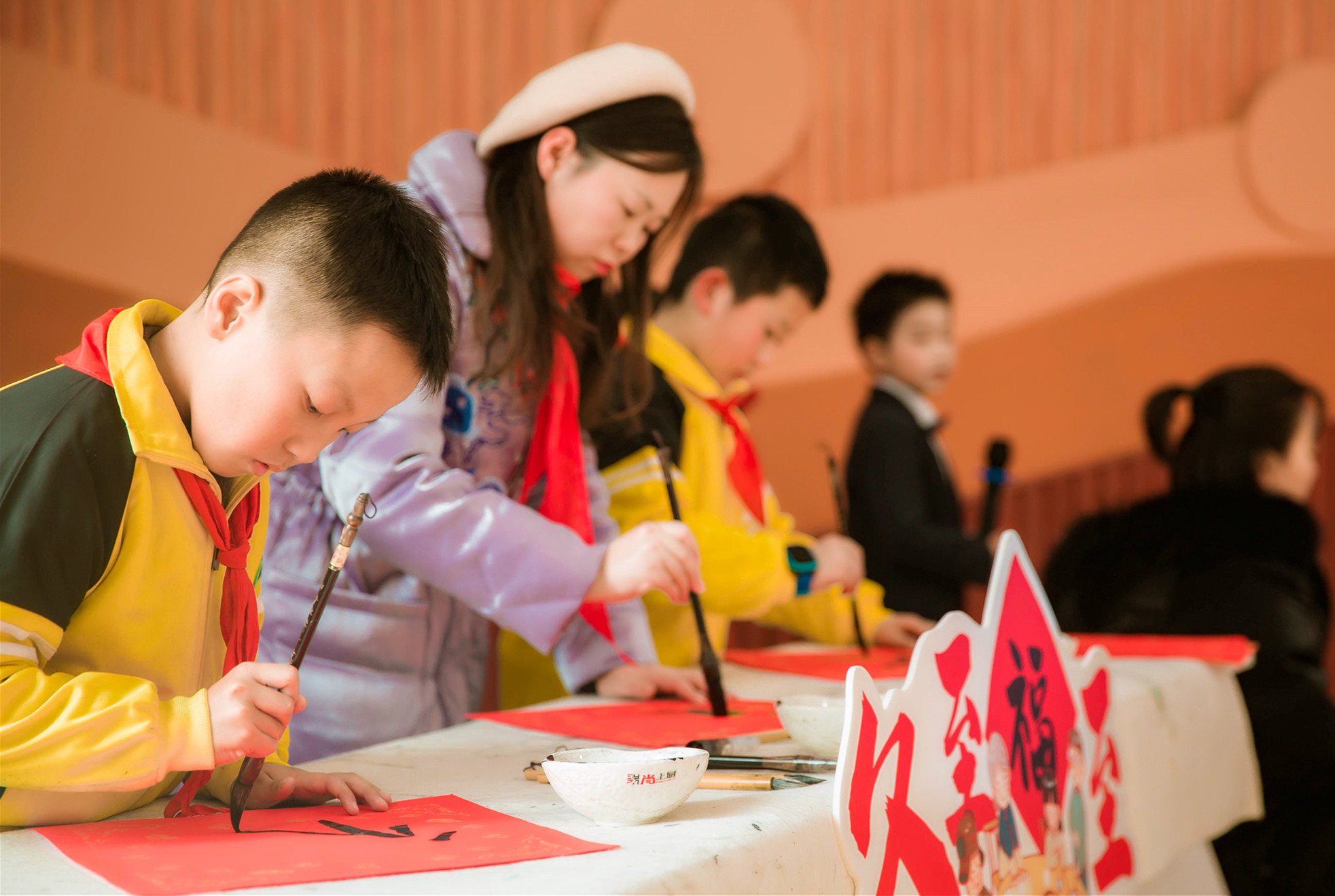 几位爱好书法的学生在老师带领下现场书写“福”字。 几位爱好书法的学生在老师带领下现场书写“福”字。