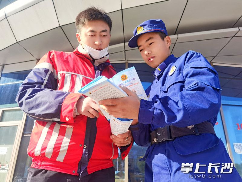 消防员向市民发放消防安全知识手册。