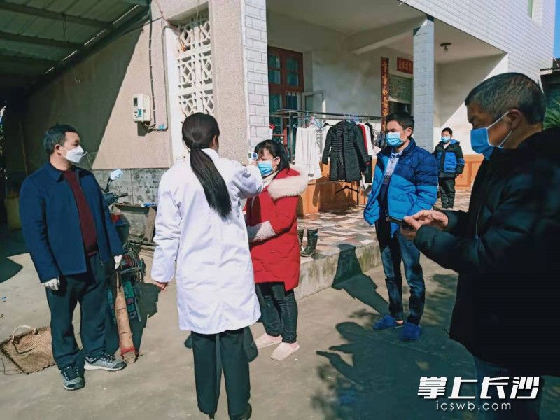 工作人员为村民测量体温。
