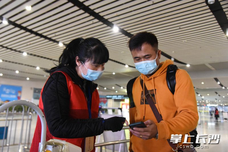 春运首日，长沙火车南站的志愿者引导乘客出示健康码并进行查验。均为长沙晚报全媒体记者 刘琦 摄