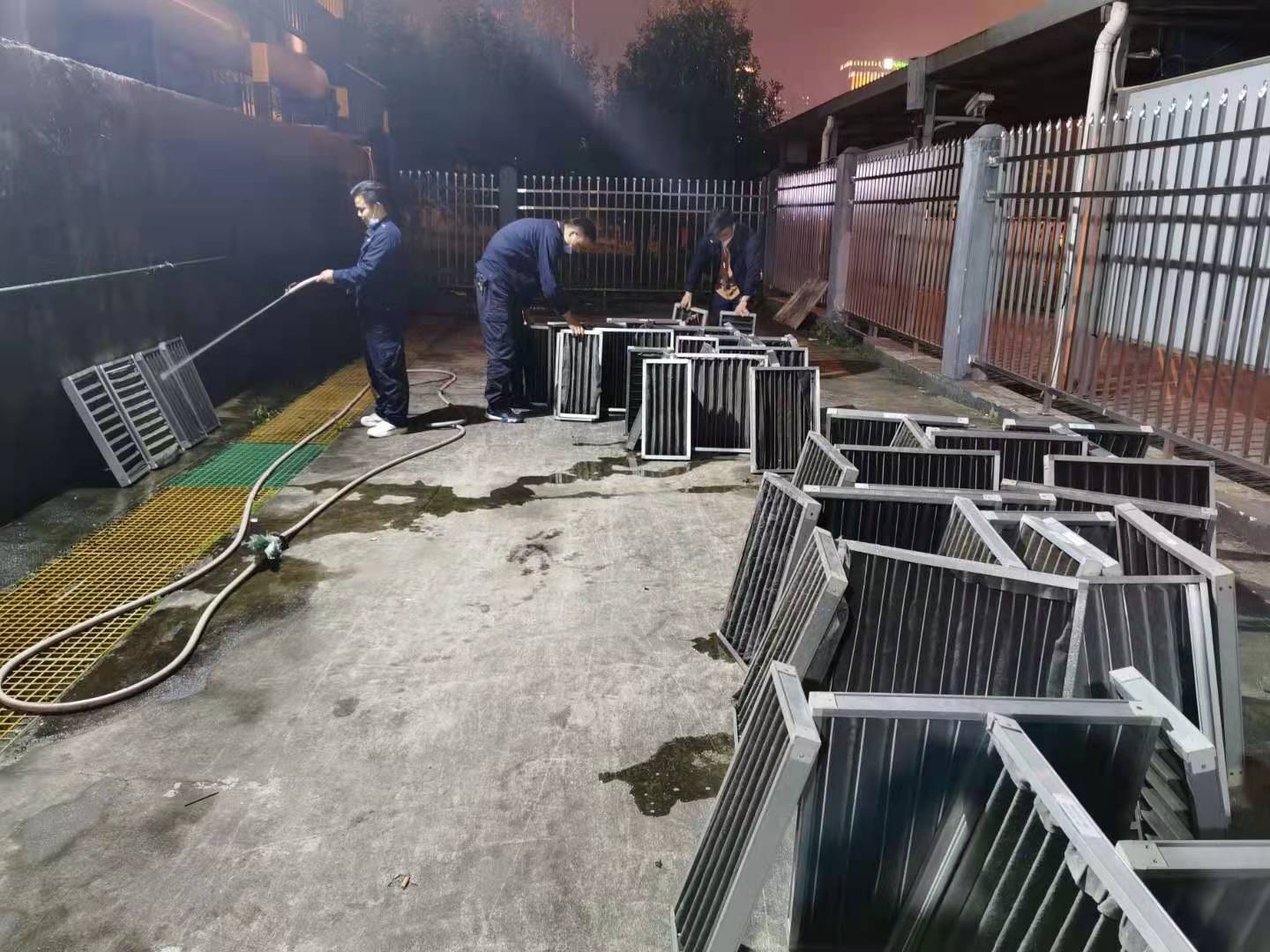 方希与同事使用高压水枪清洗空调过滤网