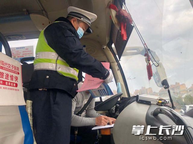 天心交警在“服务站”检查春运车辆并向驾驶人发放宣传资料。