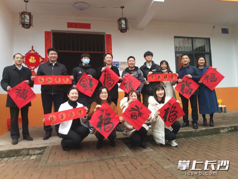 举着福字和对联，扶贫干部、志愿者、脱贫户和大学生都很开心。长沙晚报全媒体记者 王斌 摄