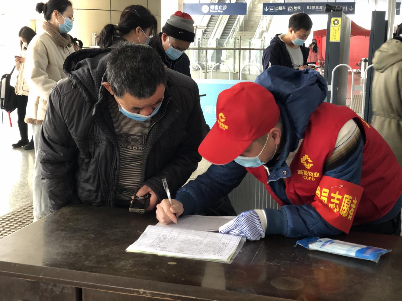 长沙城发物业的志愿者正在帮旅客登记基本信息。