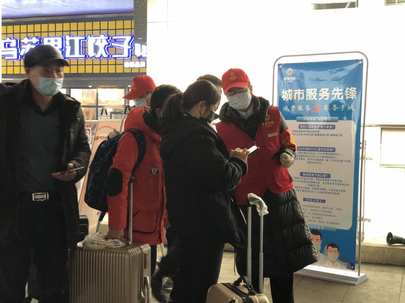 志愿者正在为过往旅客提供帮助。
