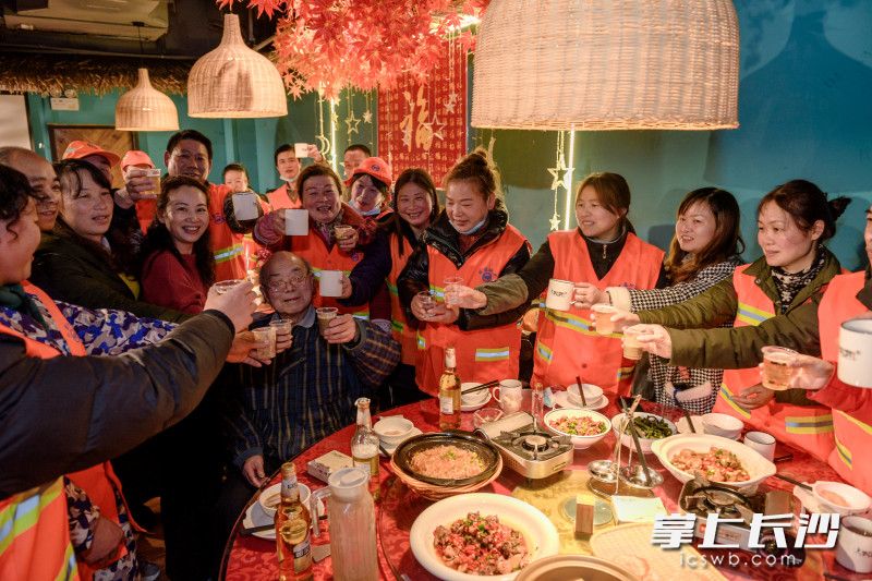大家举杯迎春，现场温馨热闹。