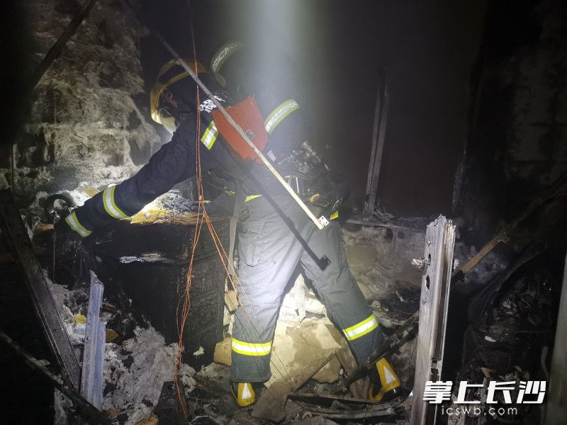 消防员灭火后，对火灾现场进行清理。长沙消防供图