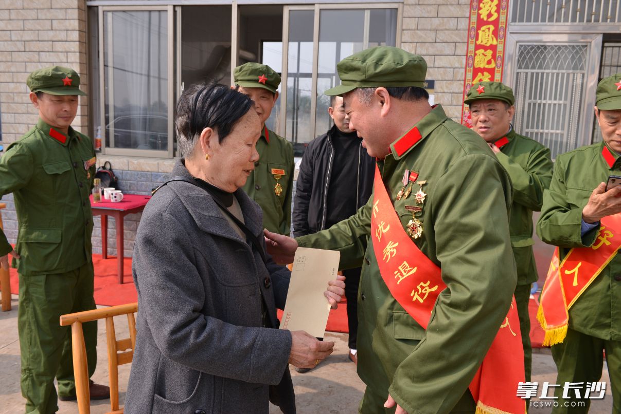 望城区高塘岭街道新阳村烈士丁正祥母亲熊玉香的家里，来了8名身穿旧军装的“儿子”。 通讯员王希明摄