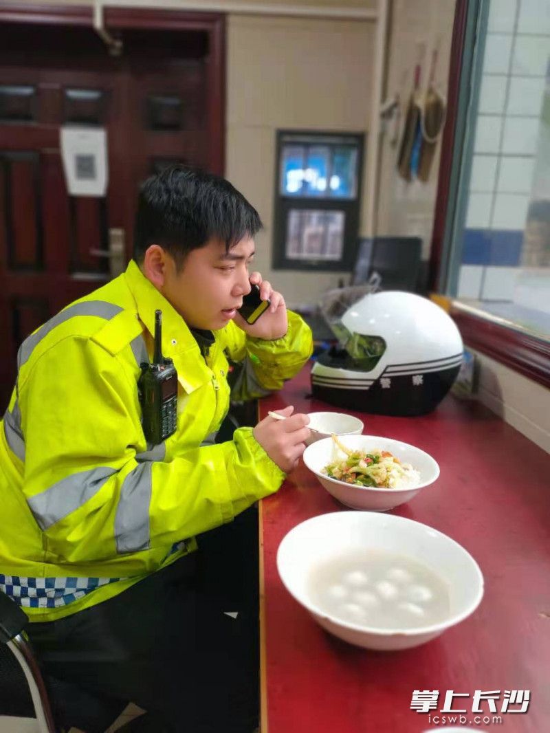 辅警易斌边吃元宵边处理警情。