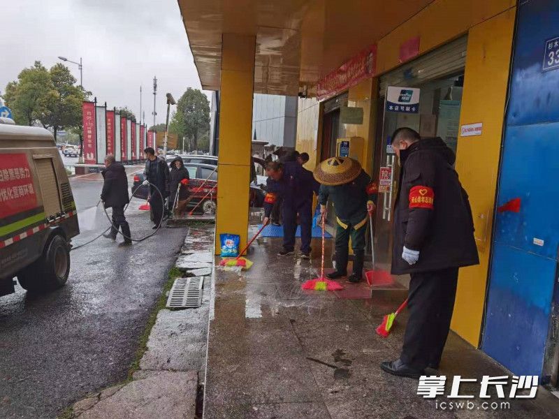 志愿者对小区门店前坪进行清洗。