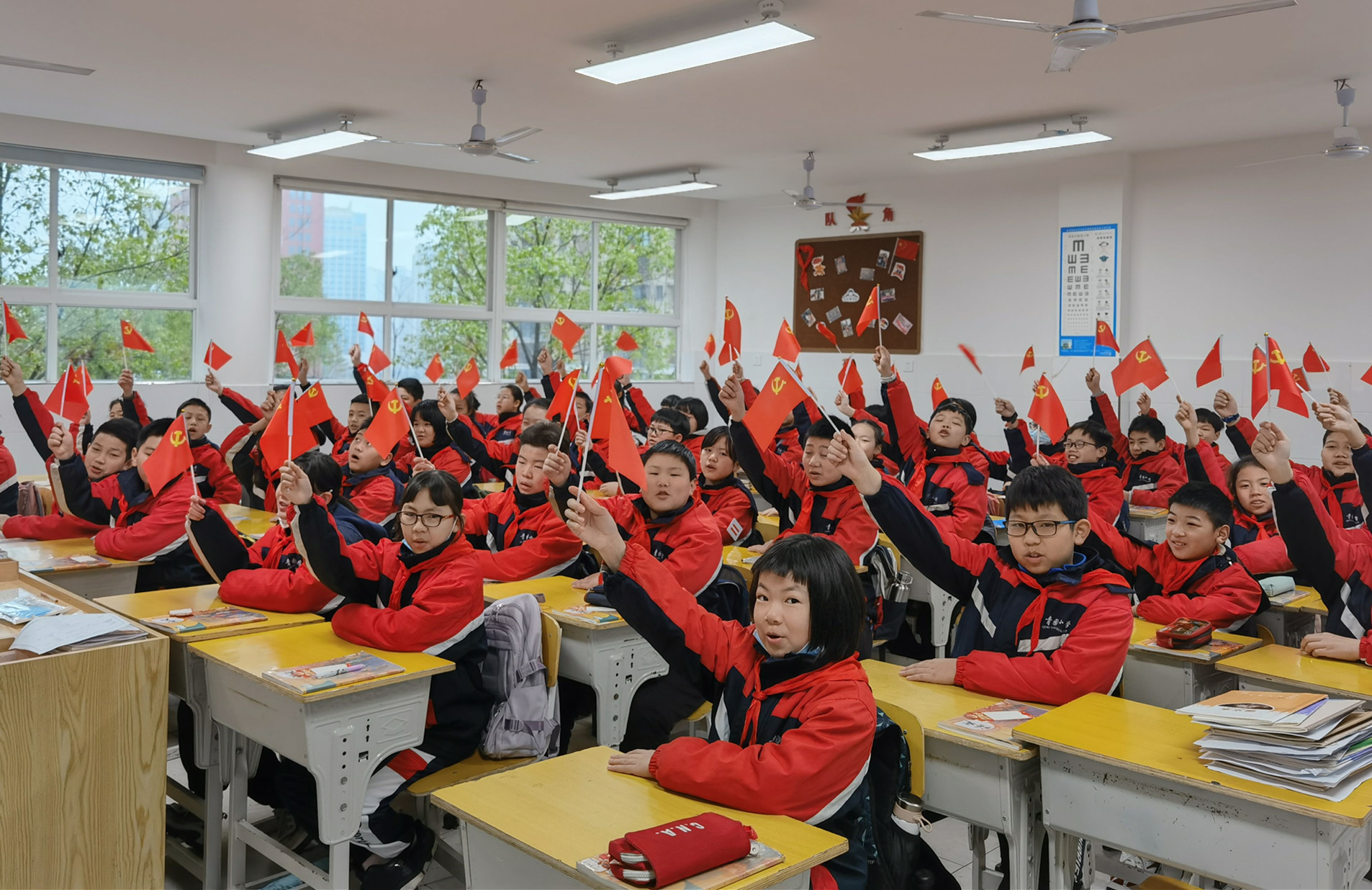 青园教育集团万芙校区的同学们挥舞小党旗，表达对建党百年的祝福。