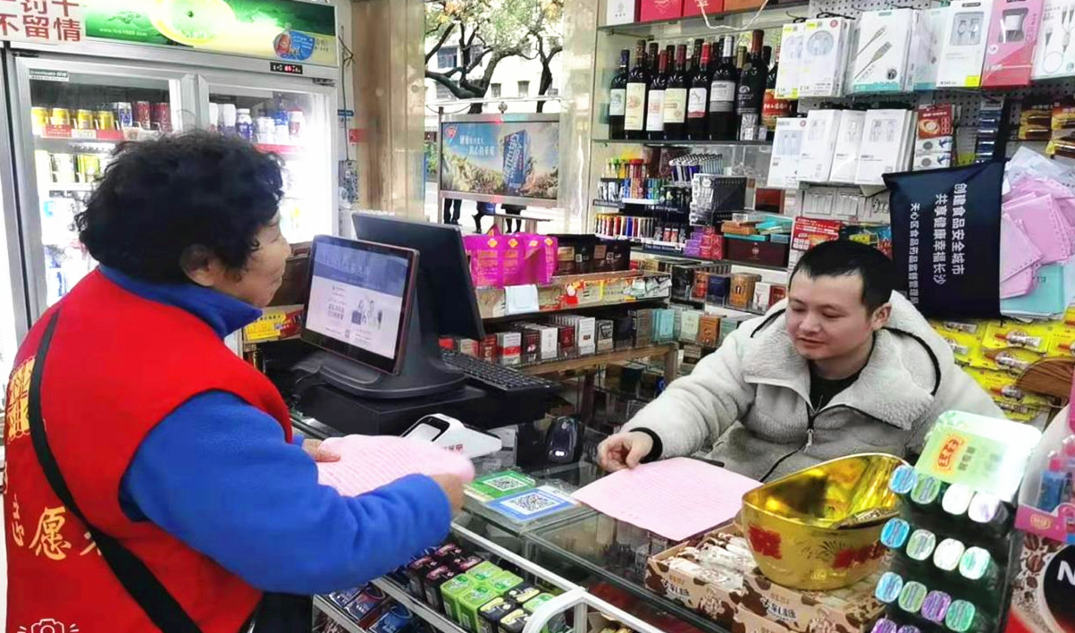 燕子岭社区志愿者上门入户，向商家、居民放发倡议书。