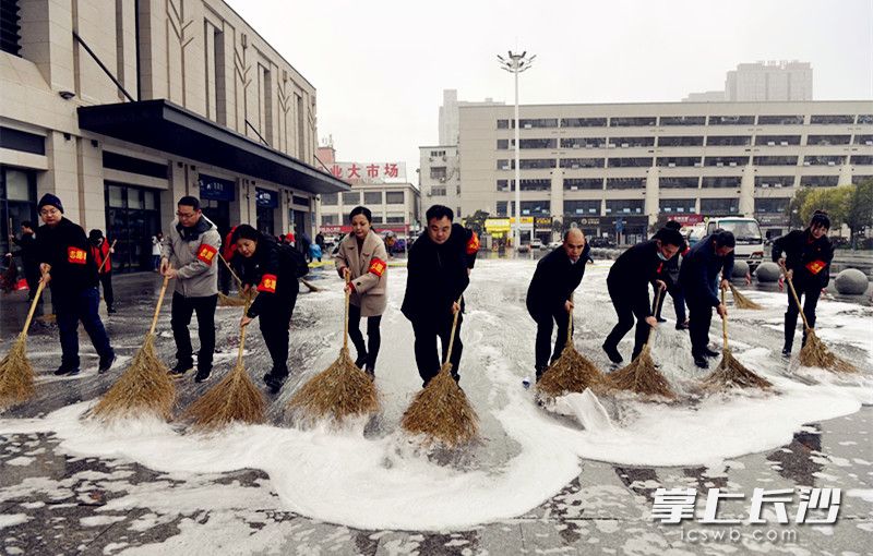 志愿者们一起清洗火车站广场。  均为长沙晚报全媒体记者 周和平 摄