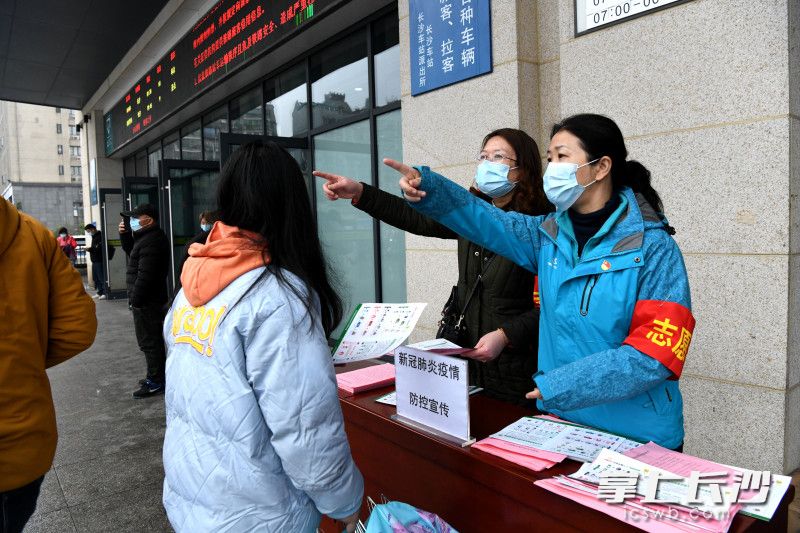 火车站出口志愿者为乘客引路。