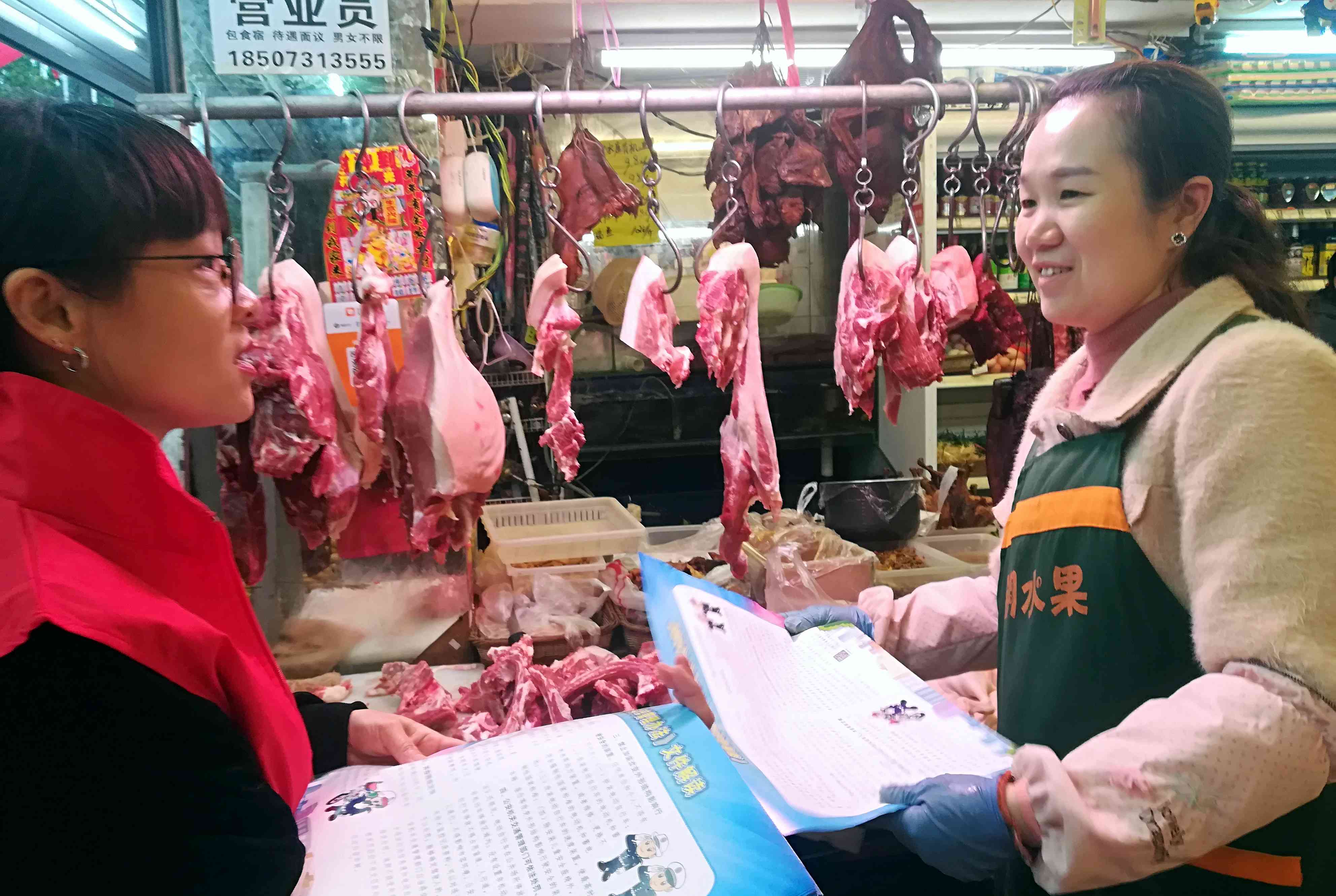 志愿者对沿街门店开展垃圾分类宣讲。