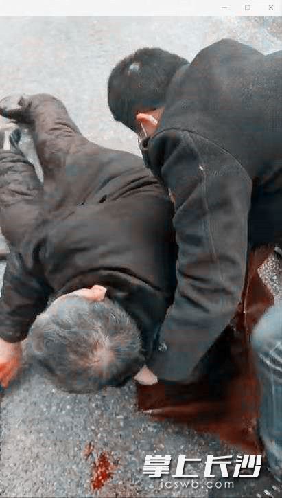 杨宇峰雨中救助摔倒受伤的老人。韭菜园街道供图 杨宇峰雨中救助摔倒受伤的老人。韭菜园街道供图