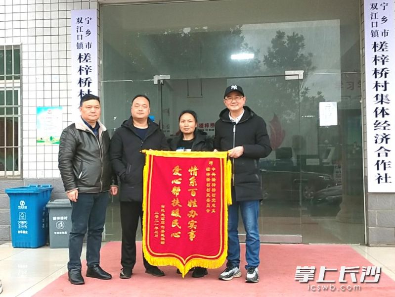 在宁乡双江口镇槎梓桥村，一名脱贫户送锦旗感党恩。受访方供图