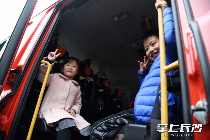 参加活动的学生登上消防车，十分开心。