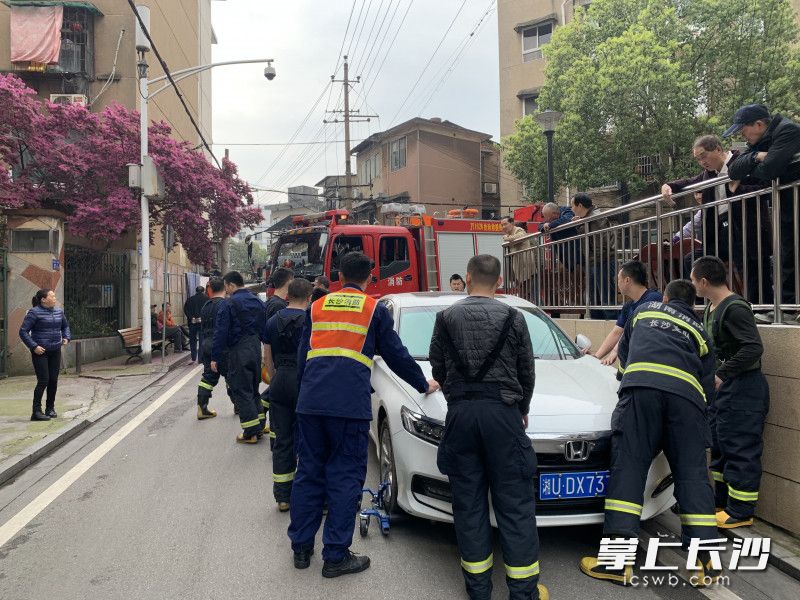 出警返回时消防车被违停的车辆挡住，消防员使用移车设备拖移车辆。长沙消防供图
