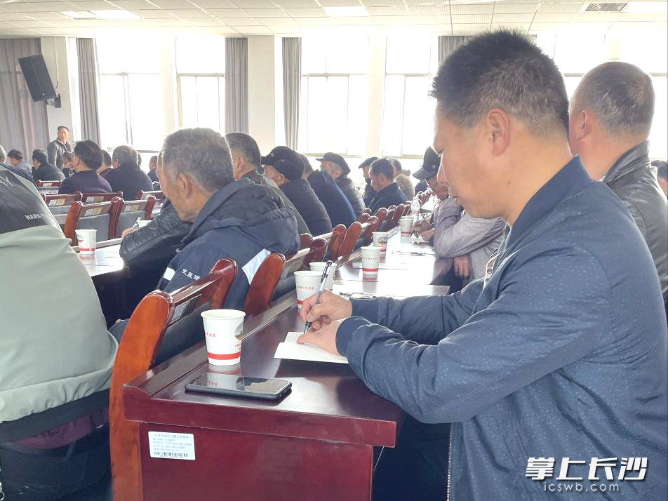 党员们认真听课，做好笔记。