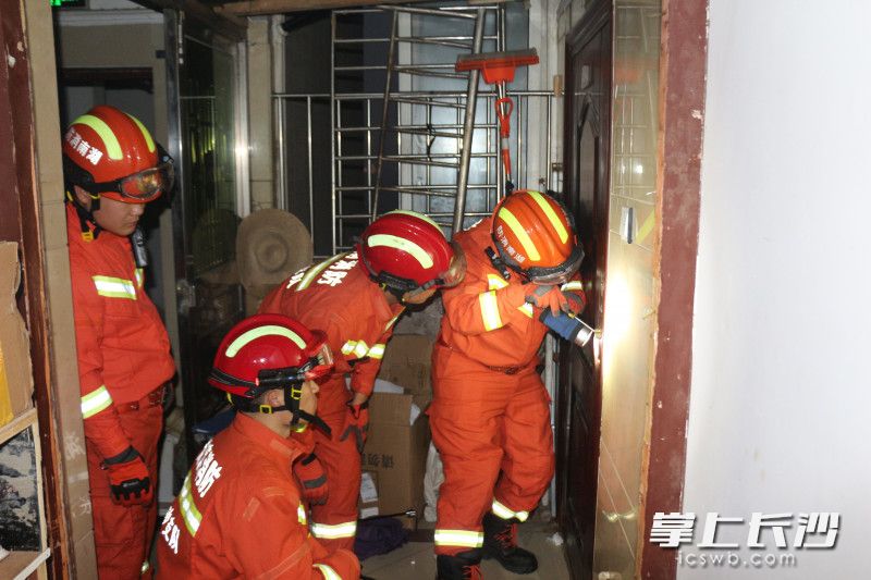 消防员使用破拆工具对房门进行破拆。均为长沙晚报通讯员 胡宇波 供图