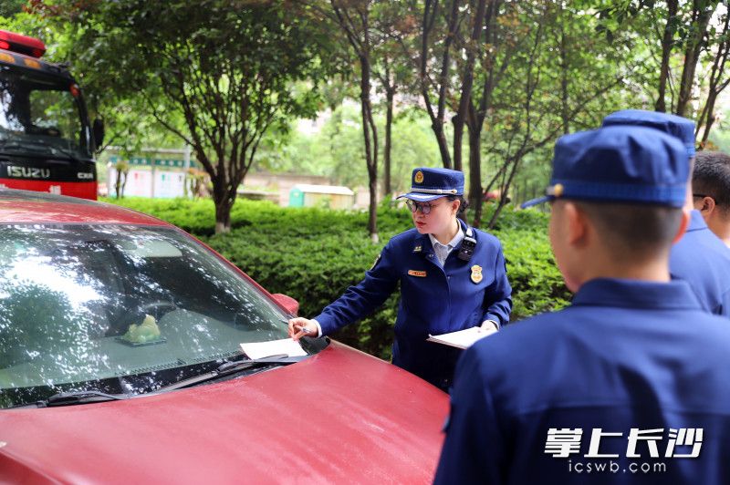 消防监督员对违停车辆进行处罚。