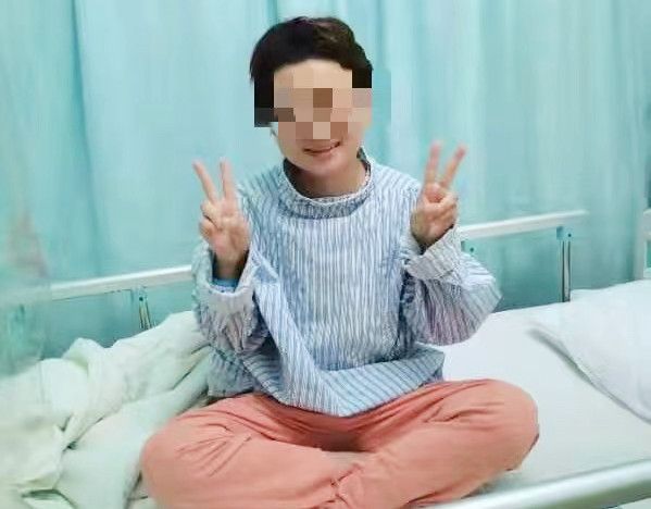 重获新生的张女士摆出象征胜利的手势。