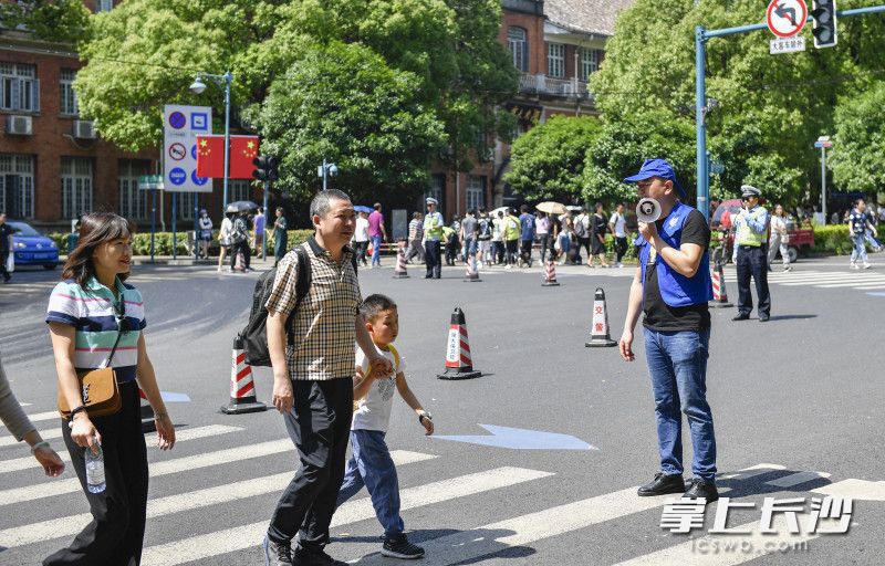 志愿者劝导游客有序通过马路。长沙晚报全媒体记者 余劭劼 摄