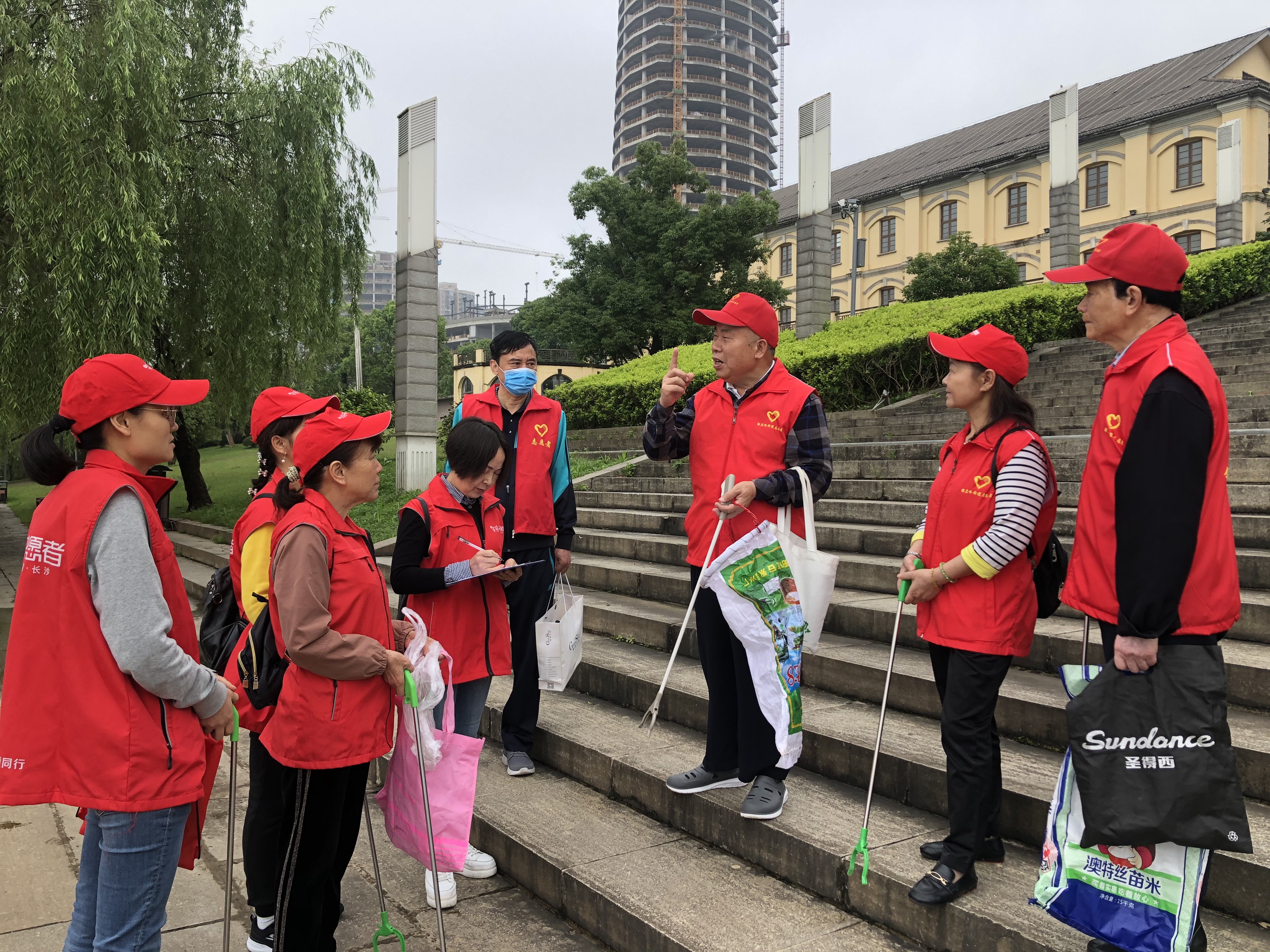 岳麓区民间河长张运和（右三）正与志愿者碰头，交流巡河注意事项。长沙晚报全媒体记者 钱娟 拍摄