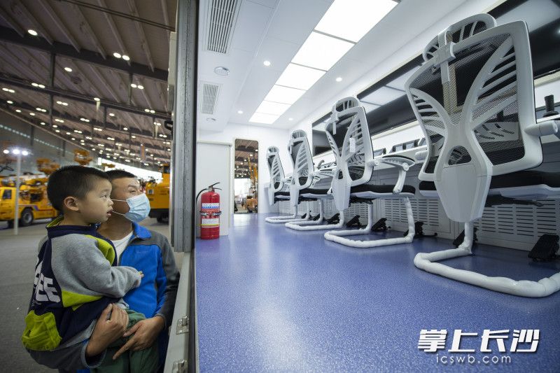 在铁建重工展台，一位家长带着孩子看着仿佛科幻片中的车载主控室。