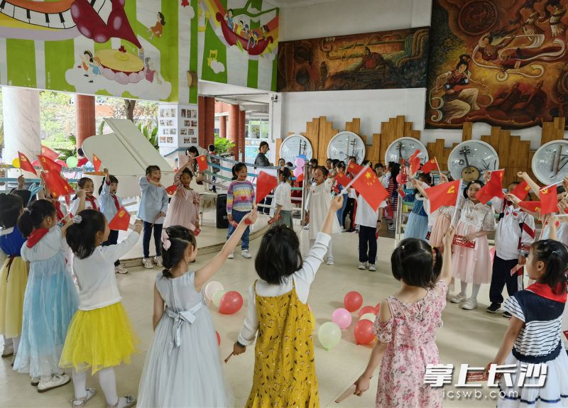 20多个一年级小朋友围成一圈，一起唱红色歌曲。均为全媒体记者 陈良 通讯员 李璐 摄