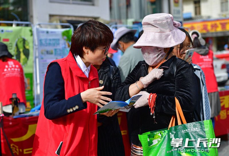 湖南短援队员顶着烈日为过往群众宣传环保理念并发放知识手册。