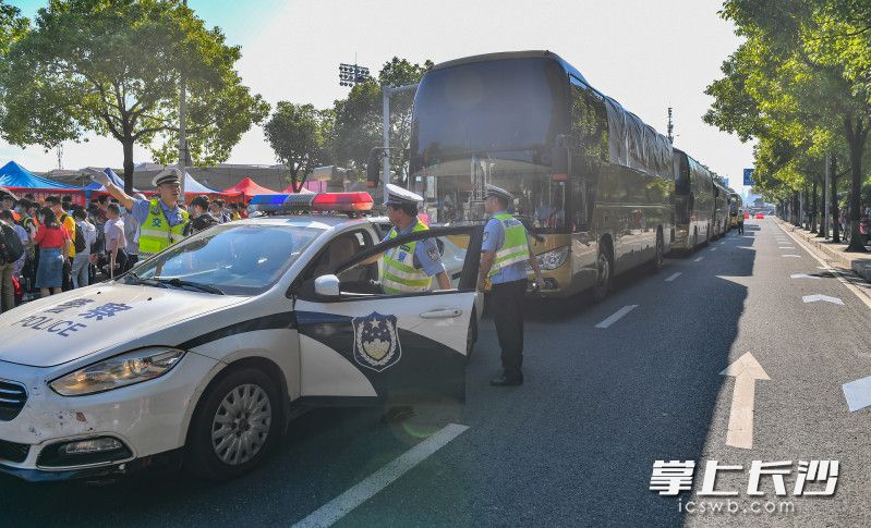 湖南师大考点，交警引导送考车辆有序进入考点。长沙晚报全媒体记者 邹麟 摄
