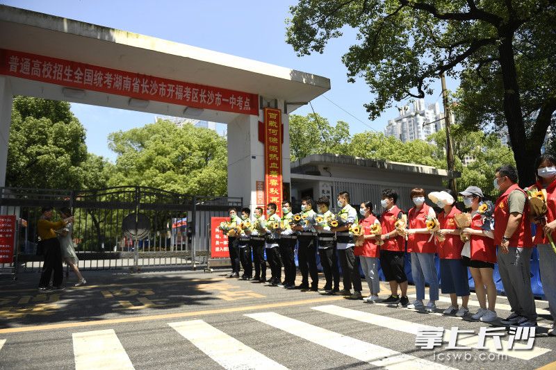 上午第一堂考试结束之后，志愿者守护在长沙市一中门口，为考生献上向日葵。长沙晚报全媒体记者 黄启晴 摄