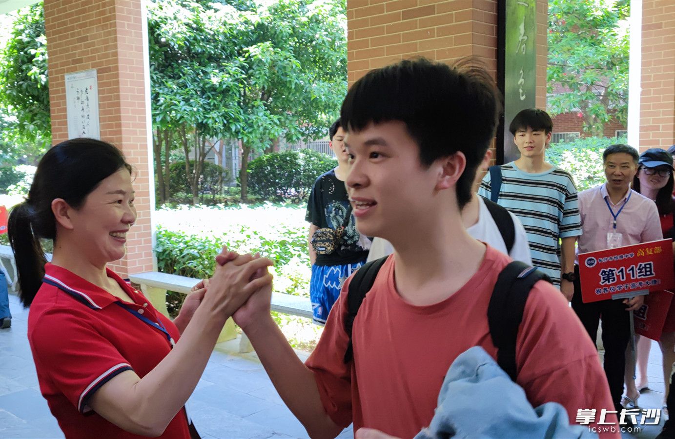 一名考生走出考点后，与付朝霞击掌庆祝。均为通讯员 李勋亮 供图