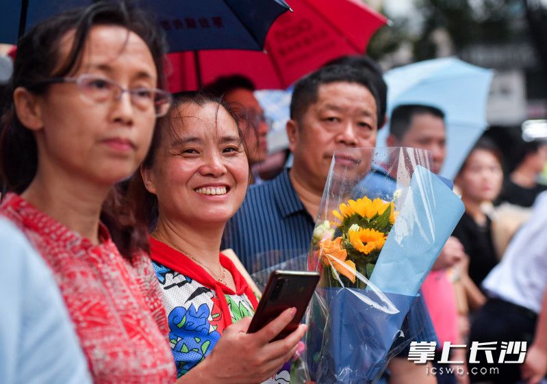 在长沙市实验中学考点外，一位家长抱着鲜花等待孩子出来。均为长沙晚报全媒体记者  邹麟 黄启晴  摄影报道