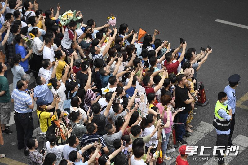 在长沙市一中考点，家长们纷纷举起手机记录考生走出考场瞬间。