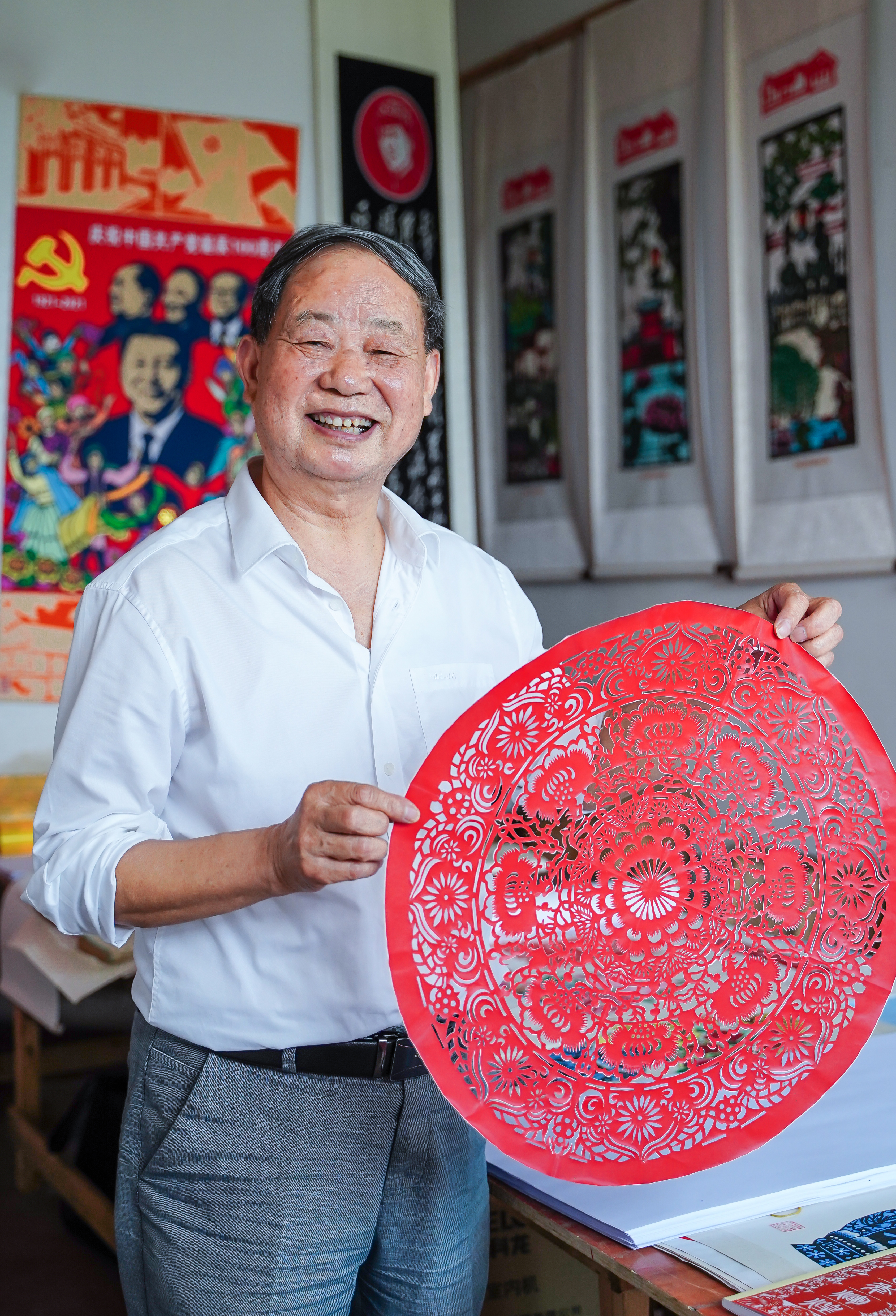 剪纸艺术家刘章喜与他的剪纸作品《富贵万年》 。长沙晚报全媒体记者 易亿 摄