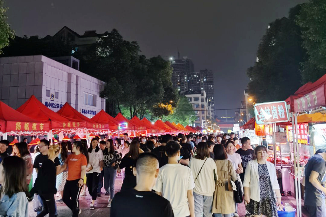 作为长沙著名的“打卡胜地”，扬帆夜市内整齐的地摊位一线铺开，行走在其中的市民、游客三五成群。均为长沙晚报全媒体记者 刘攀 摄