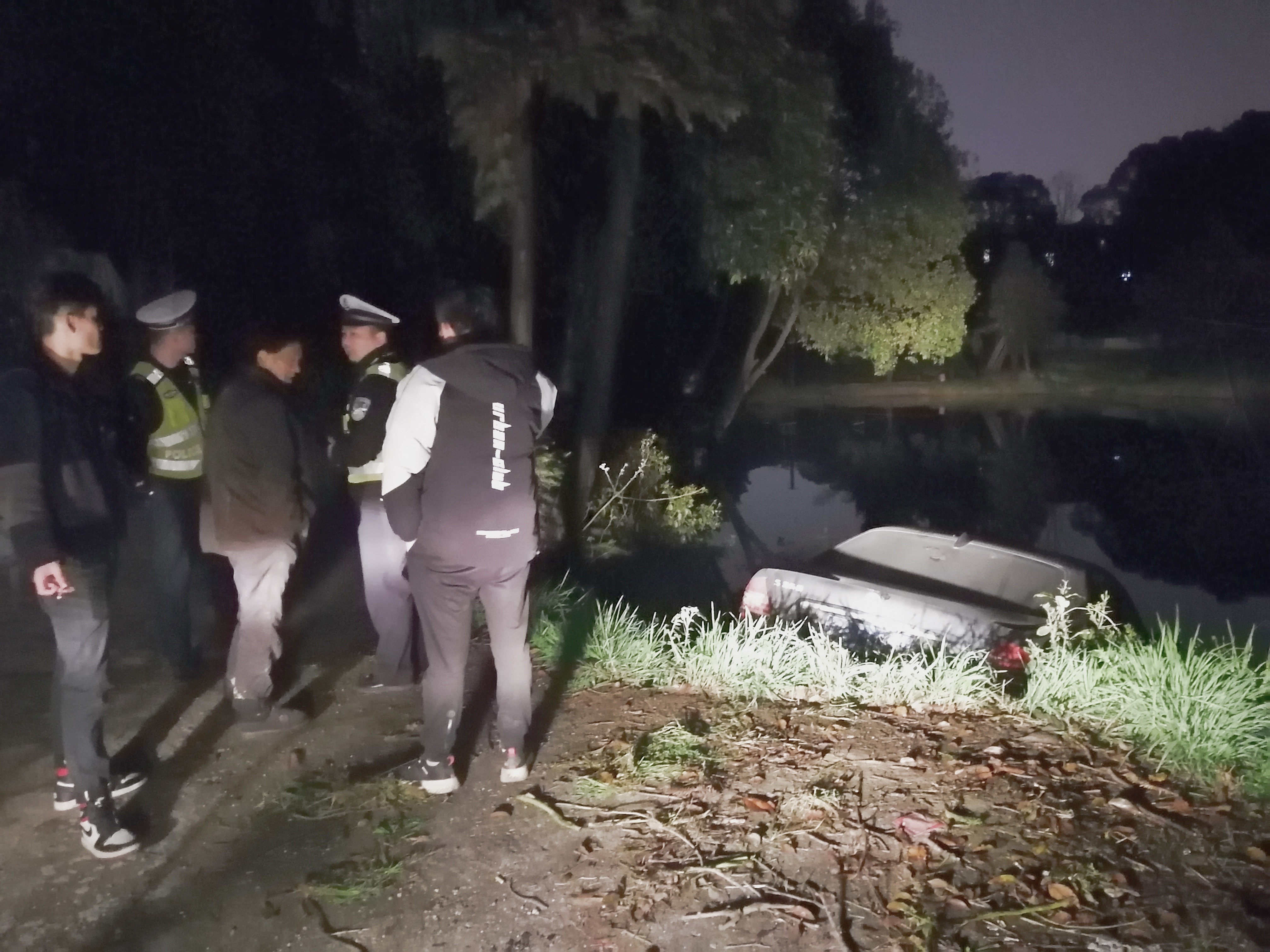 豪华轿车傍晚冲出道路落入池塘。受访者供图