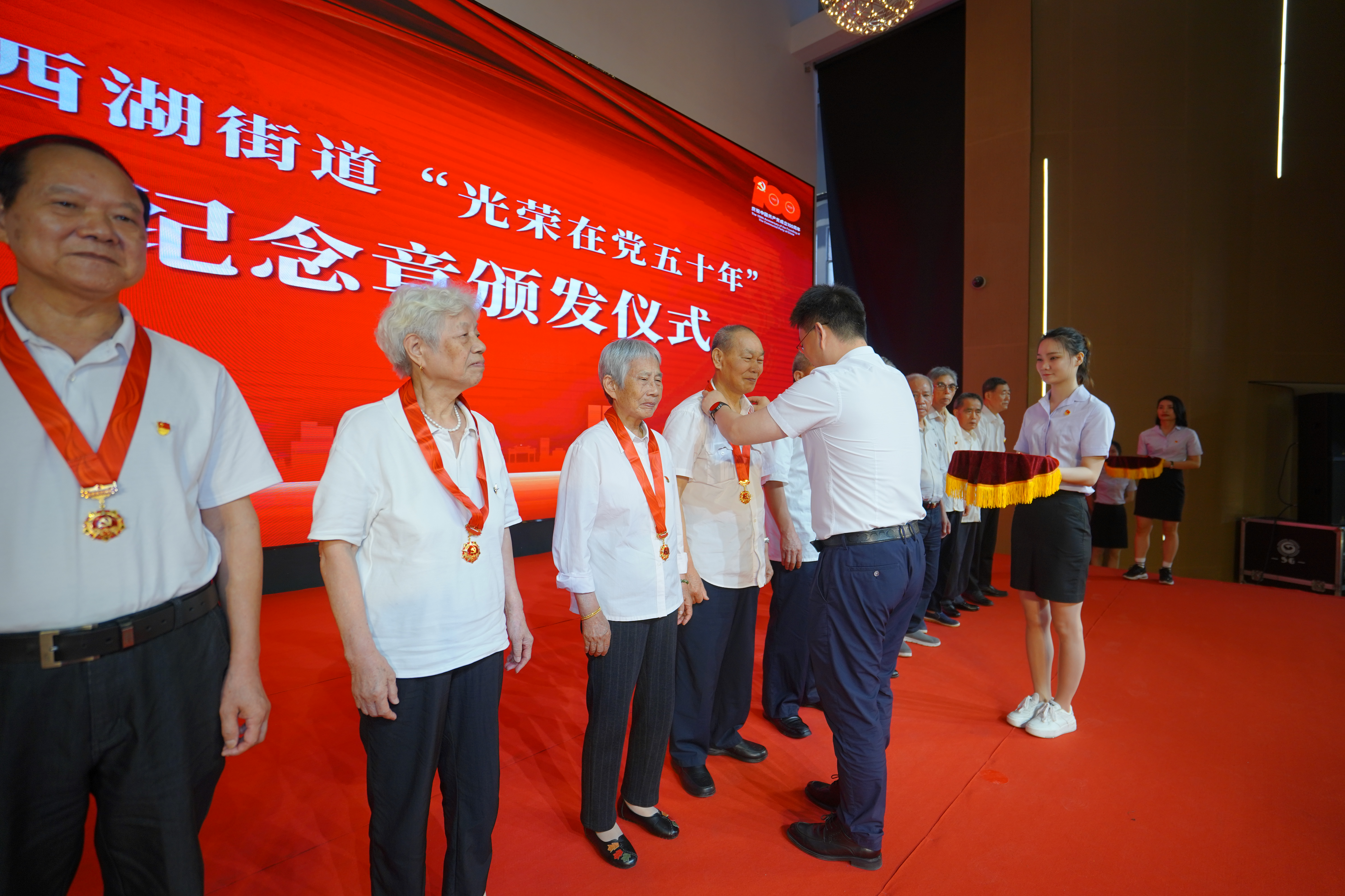 为“光荣在党50年”老党员颁发纪念章。