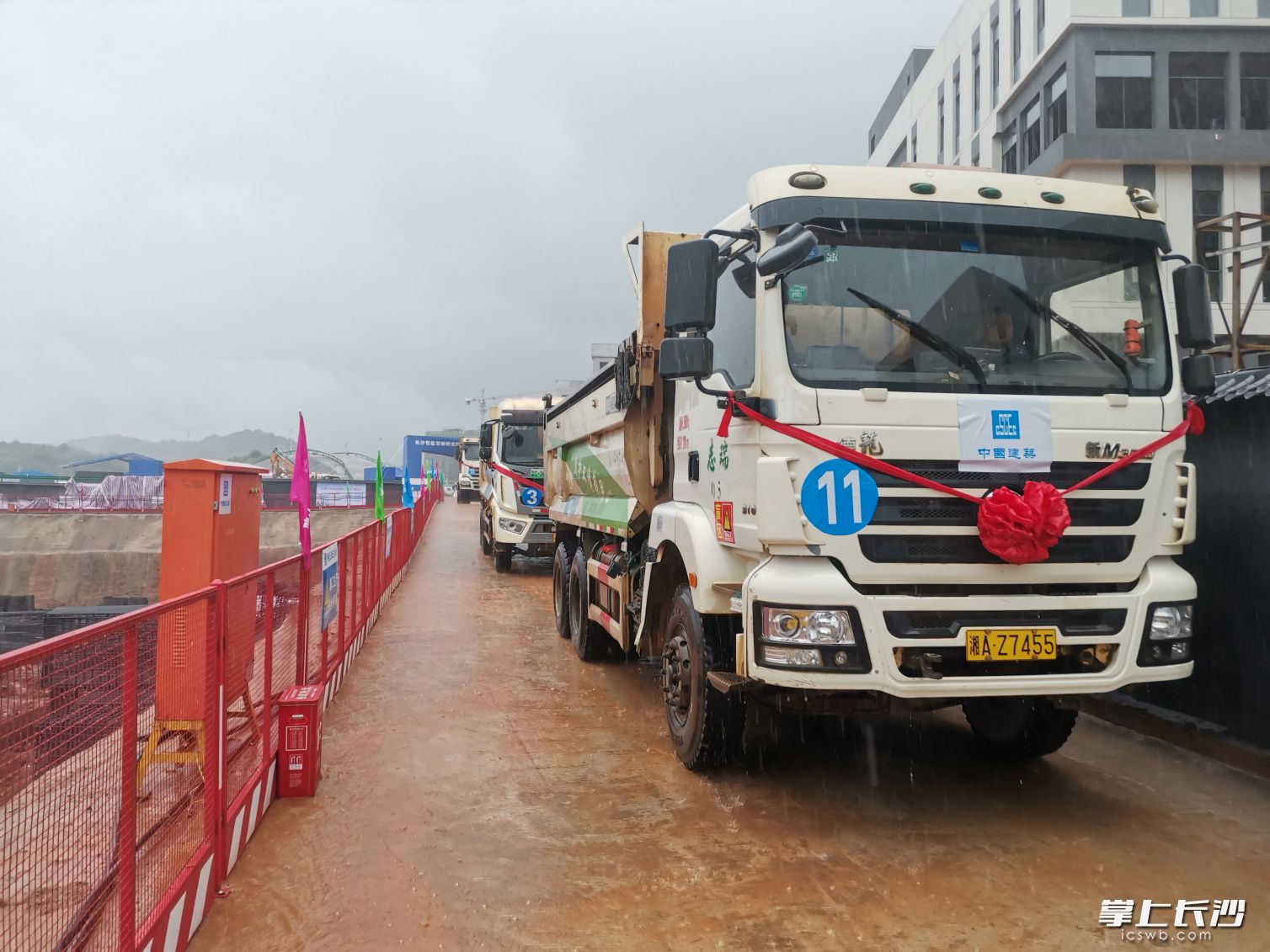 开竣工仪式后，工程车队迎着暴雨缓缓驶出。均为长沙晚报实习生 金晨宇 摄
