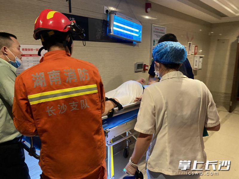 消防员成功将孕妇从30楼转运至1楼，准备送上救护车。